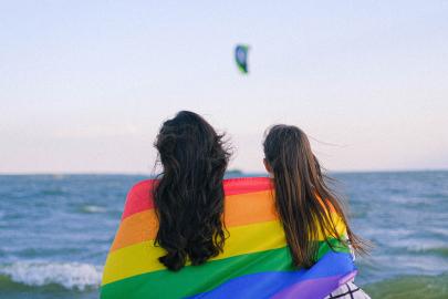 Two people sitting with rainbow flag