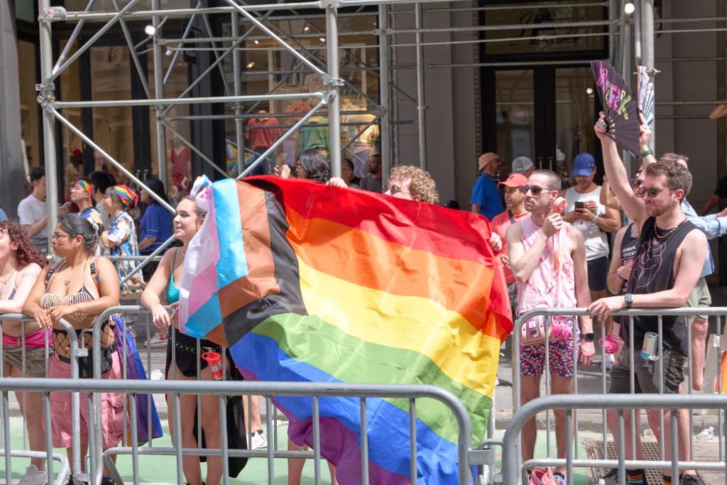 Person holding inclusive pride flag