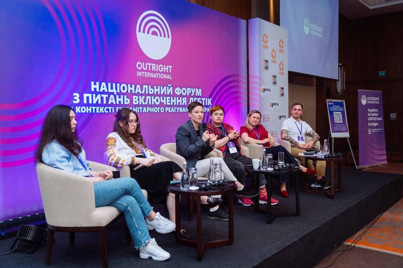 Panelist sit on a stage at Ukraine's National Forum with a purple backdrop